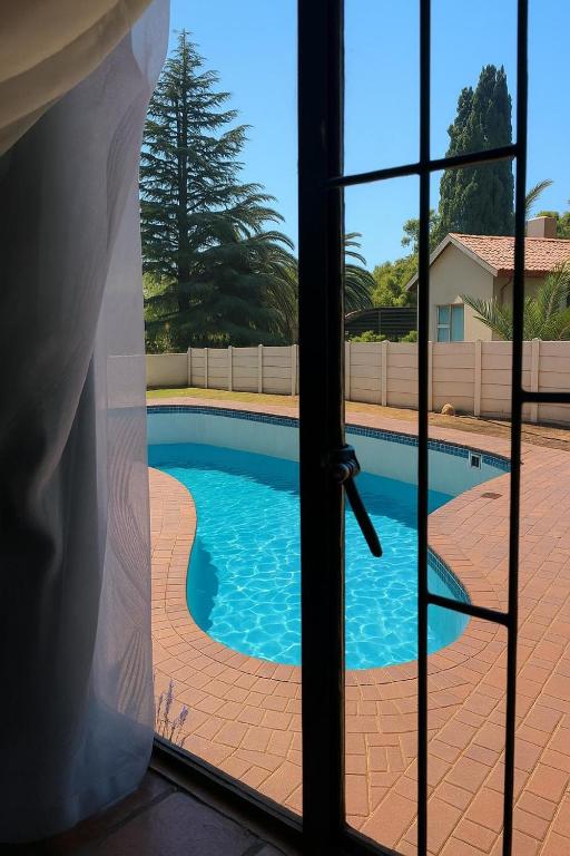 a view of a swimming pool through a window at Inconova fly in Kempton Park