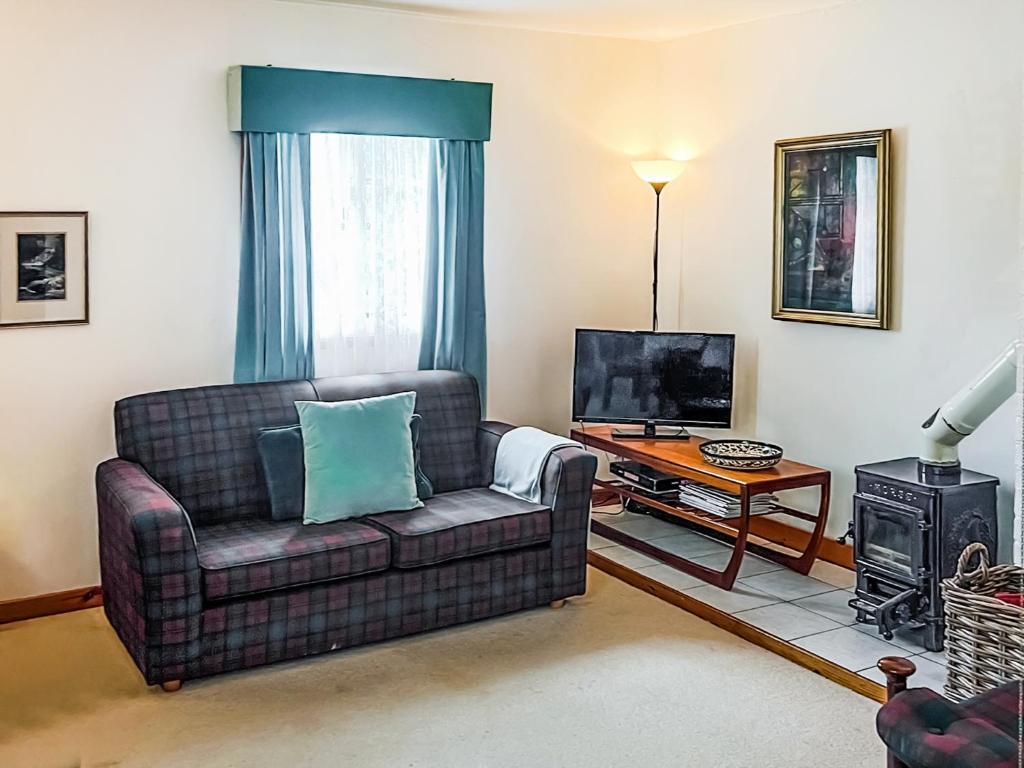Whiting BayにあるTigh An Droma Lodgeのソファとテレビのあるリビングルーム