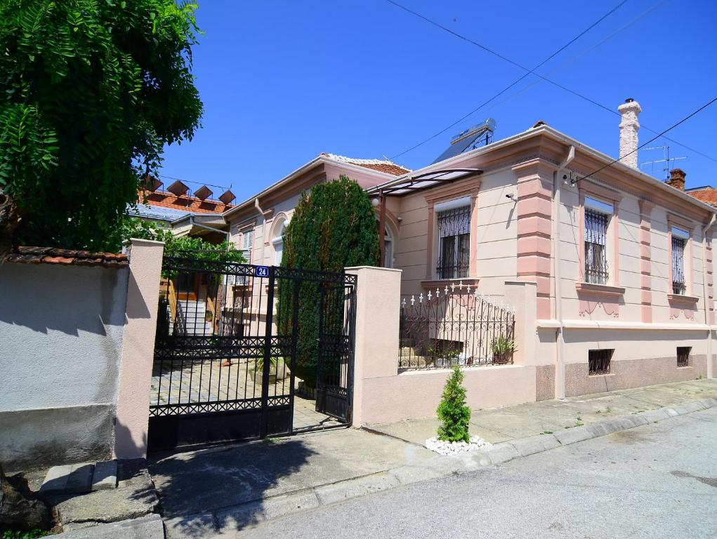a large pink house with a black gate at Guest House Antika in Prilep