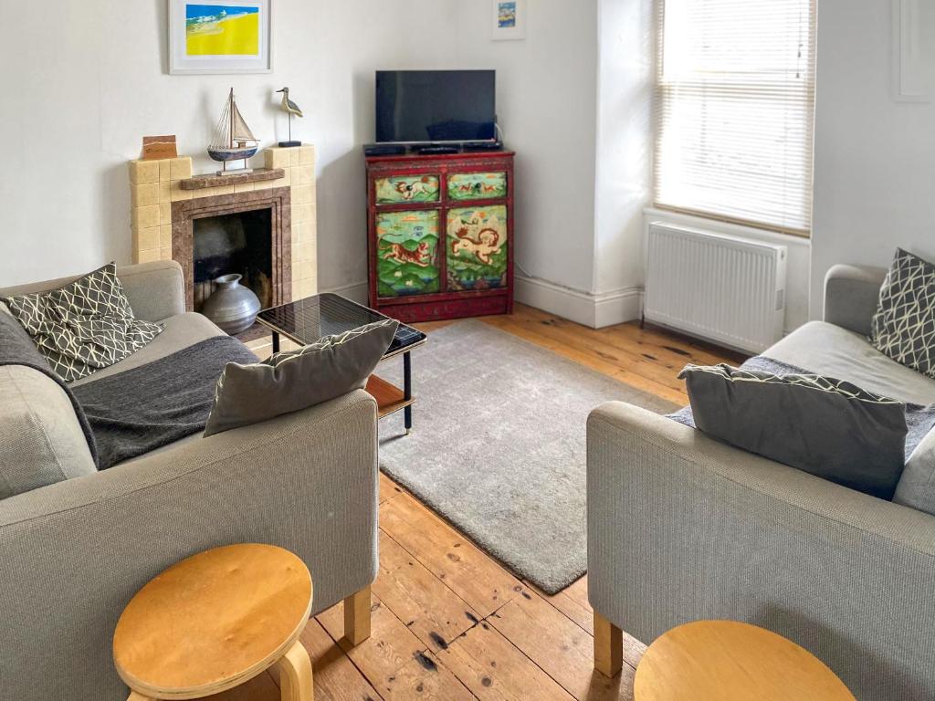 a living room with two couches and a fireplace at Nautilus in St Ives