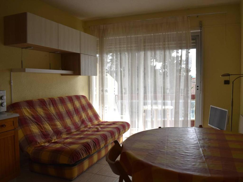 a living room with a couch and a table at Studio Cabine Confortable - Proche Centre avec Parking - FR-1-580-31 in Font Romeu Odeillo Via