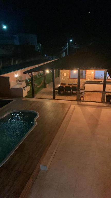 an outdoor patio at night with a swimming pool at Casa Mar-A-Lagoa in São Pedro da Aldeia