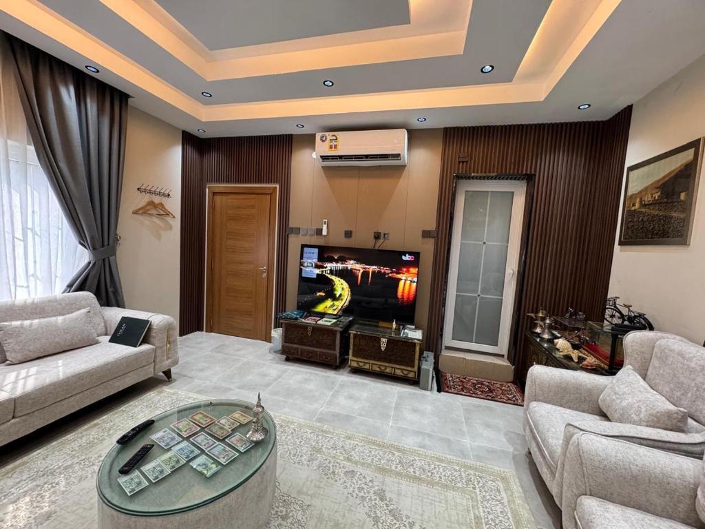 a living room with a couch and a tv at شقق الفندقية للتأجير اليومي in Fulūj Sayghah