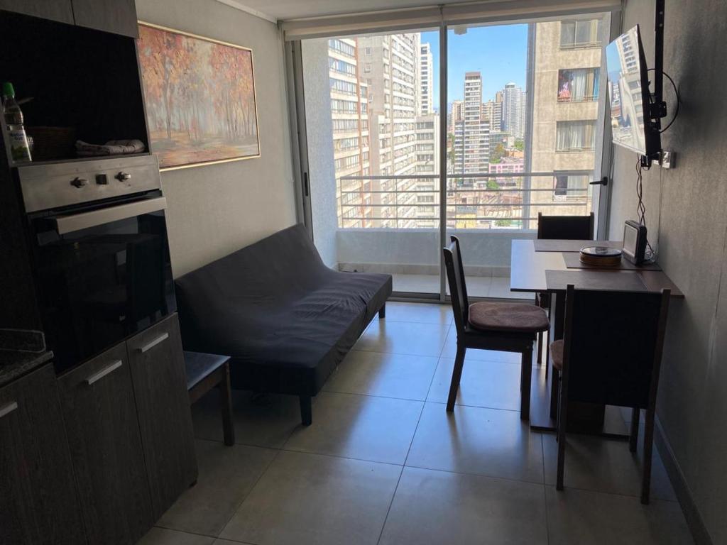 ein Wohnzimmer mit einem Sofa, einem Schreibtisch und einem Fenster in der Unterkunft Ruta 2Cabañas Ruta del Lago in Puerto Varas