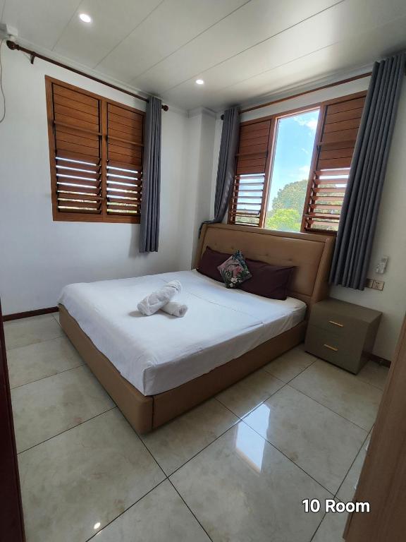 a bedroom with a bed in a room with windows at Alice Apartment 02 in Nadi