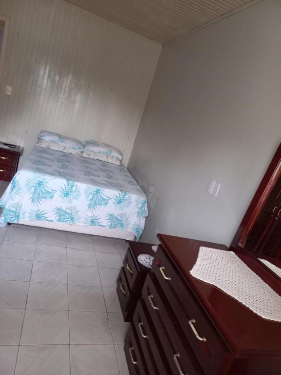 ein kleines Schlafzimmer mit einem Bett und einer Kommode in der Unterkunft Casa da Marina in Três Coroas