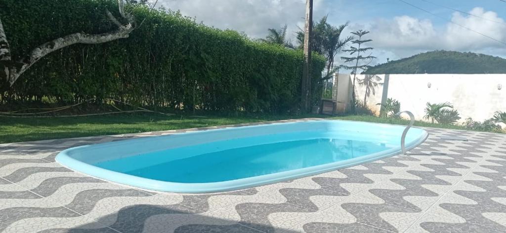 una piscina azul en un patio de azulejos en Casa na Serra, en Mulungu
