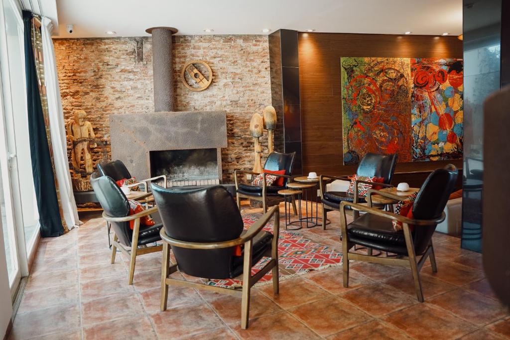 a living room with chairs and a fireplace at Los Muelles Boutique Hotel in Carmelo