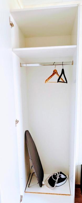 a white room with a surfboard on a shelf at Dal Homestay Haven 4U in Dal