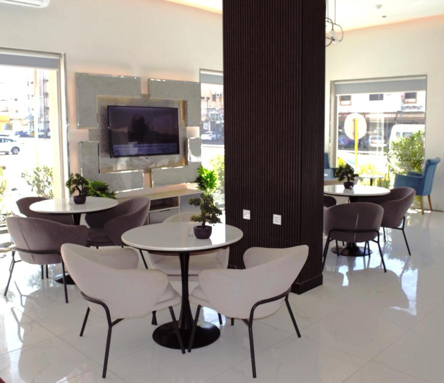 a dining room with two tables and chairs and a tv at المواسم in Tabuk