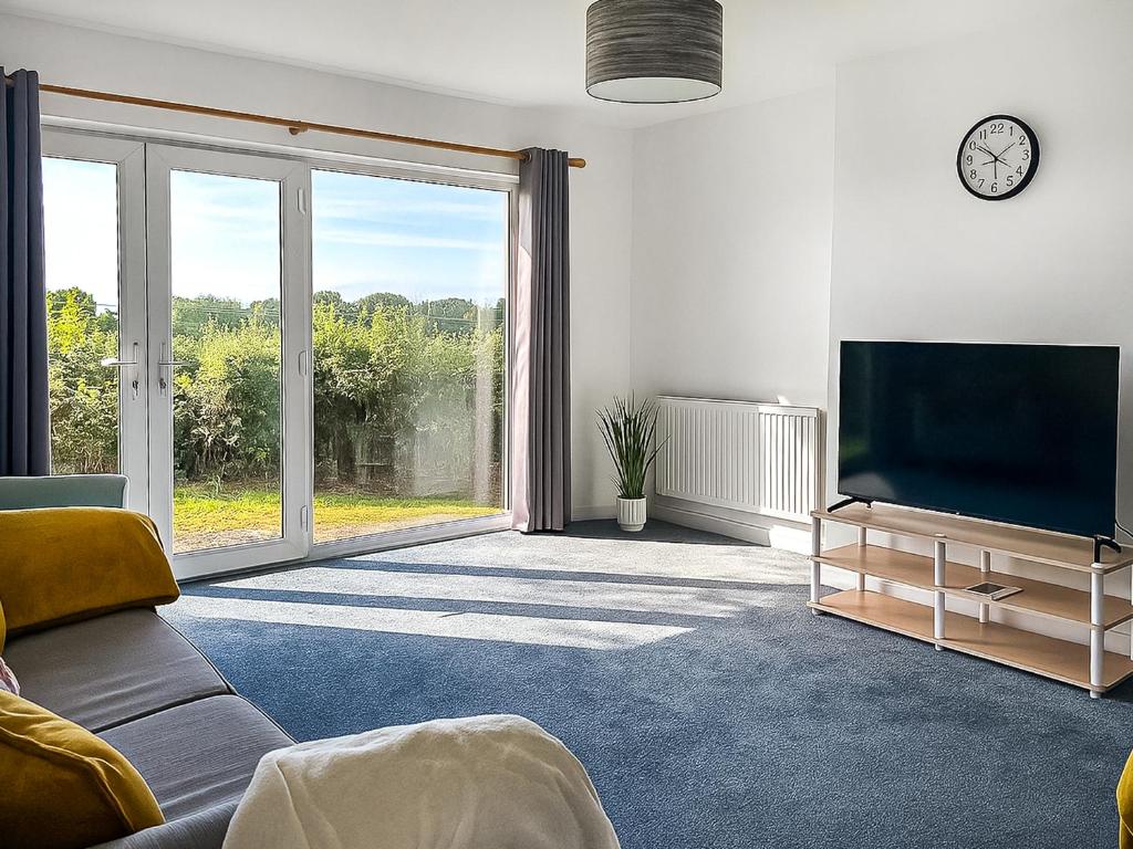 a living room with a tv and a large window at Revita in Hale