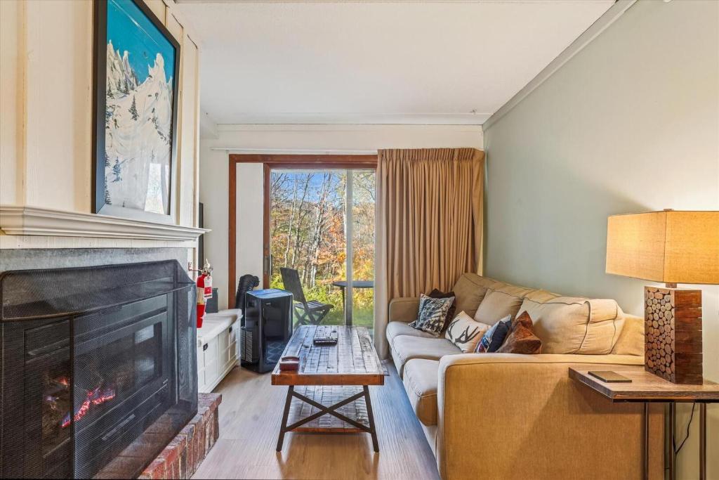 a living room with a couch and a fireplace at Whiffletree H1 in Killington Village