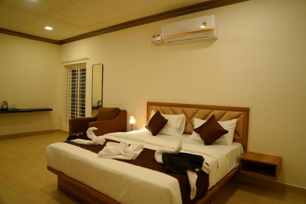 a bedroom with a large bed and a chair at Queen's Villa Yercaud in Yercaud