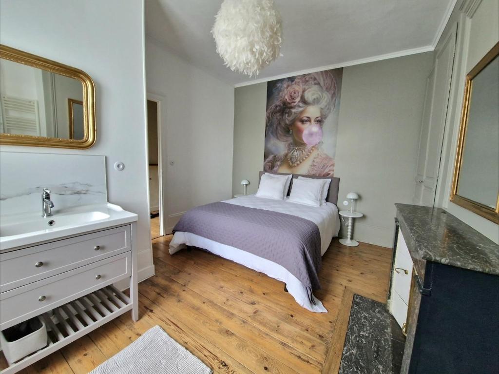 a bedroom with a bed and a sink and a mirror at Le Secret - Cozy Normandy Home with garden in Neufchâtel-en-Bray