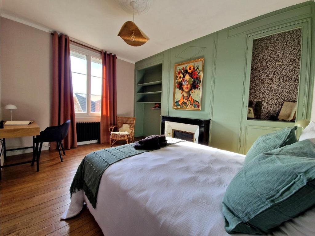 Un dormitorio con una cama y un escritorio y una ventana. en Le Secret - Cozy Normandy Home with garden, en Neufchâtel-en-Bray