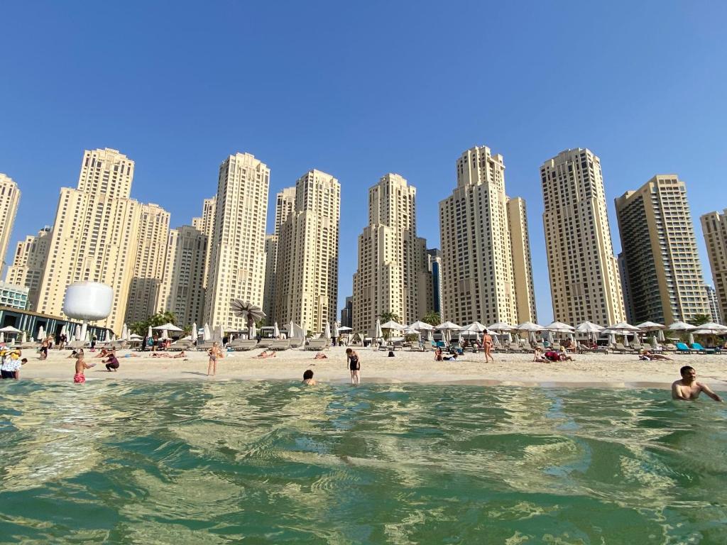 a group of people in the water at a beach at The Devine Homes in Dubai