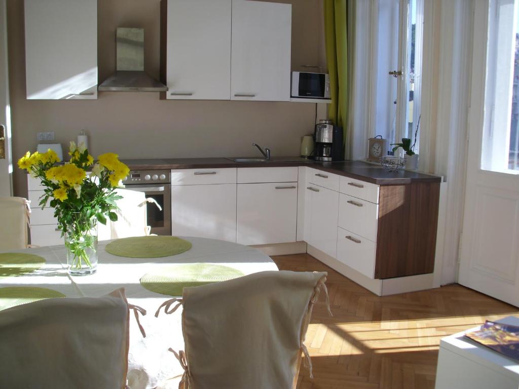 una cocina con una mesa con un jarrón de flores. en Apartment in City Center - MORASSI, en Karlovy Vary
