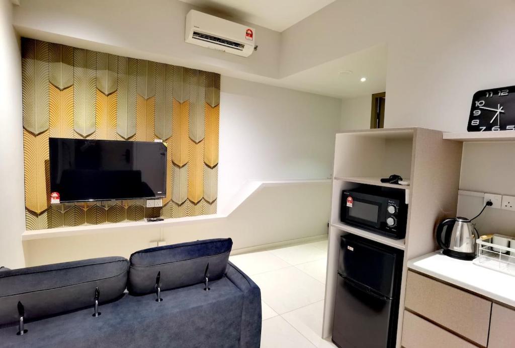 a living room with a couch and a tv at Seaview Cozy BS Homestay in Kota Kinabalu