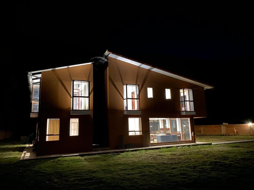 une maison la nuit avec les lumières allumées dans l'établissement Apus Paradise House Valle Sagrado, à Urubamba