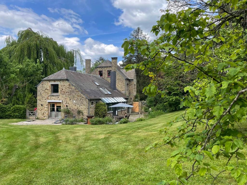 an old stone house with a grass yard at Gite grand jardin nature Ardenne Luxembourg in Nassogne