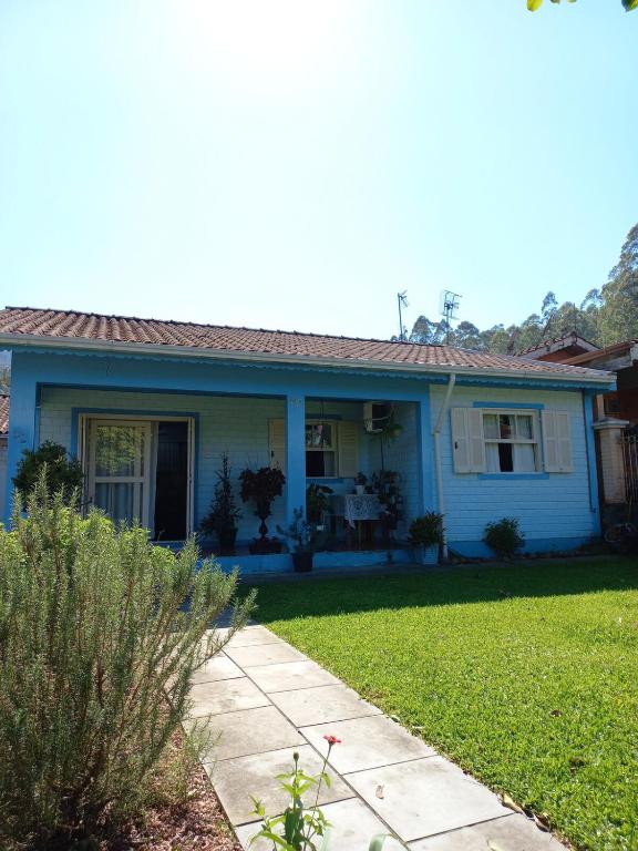 a blue house with a lawn in front of it at Casa Azul da Marina in Três Coroas