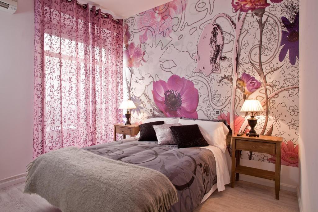 um quarto com uma cama com papel de parede floral cor-de-rosa em Hostal Foster em Madri