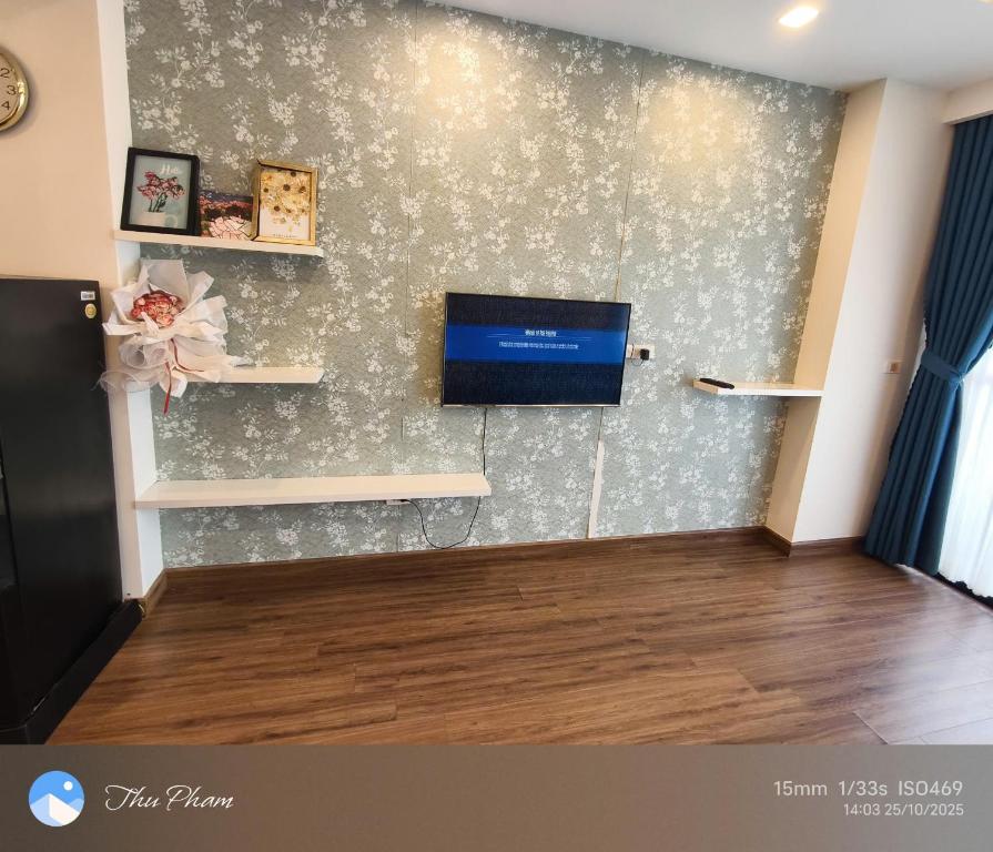 a living room with a tv on a wall at Chanhchua Apartment Quy Nhon in Quy Nhon