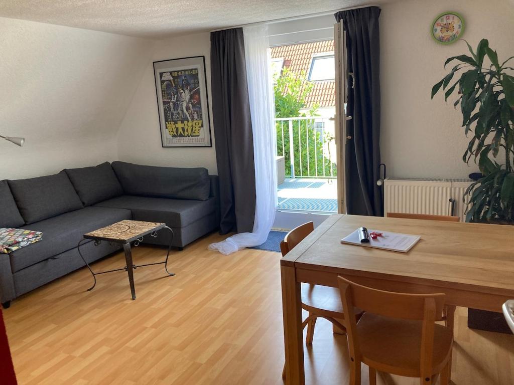 een woonkamer met een bank en een tafel bij RoDo - kleines ruhiges Condo an der A8 in Kirchheim unter Teck