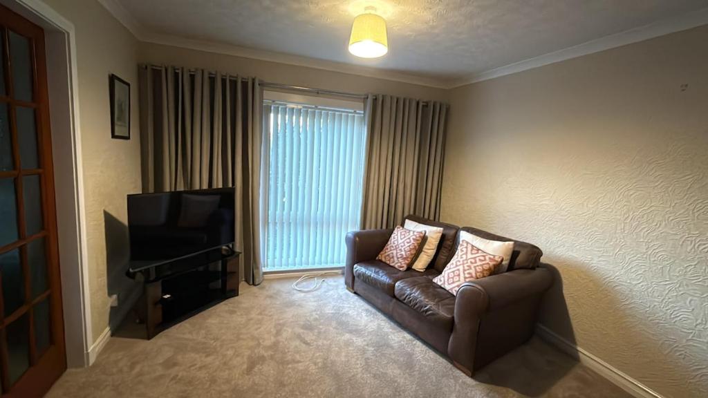 ein Wohnzimmer mit Sofa und Fernseher in der Unterkunft Lesmar Highland Retreat in Fort William