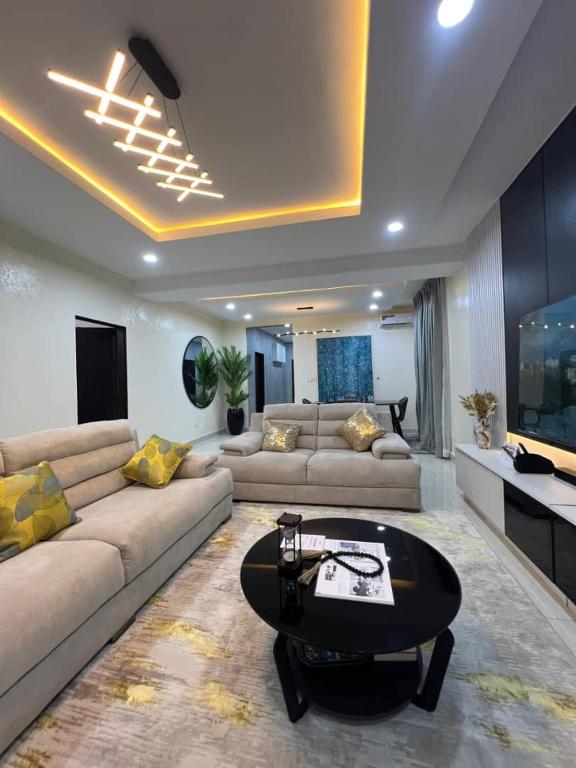 a living room with a couch and a table at Nouveau Apartment in Abuja