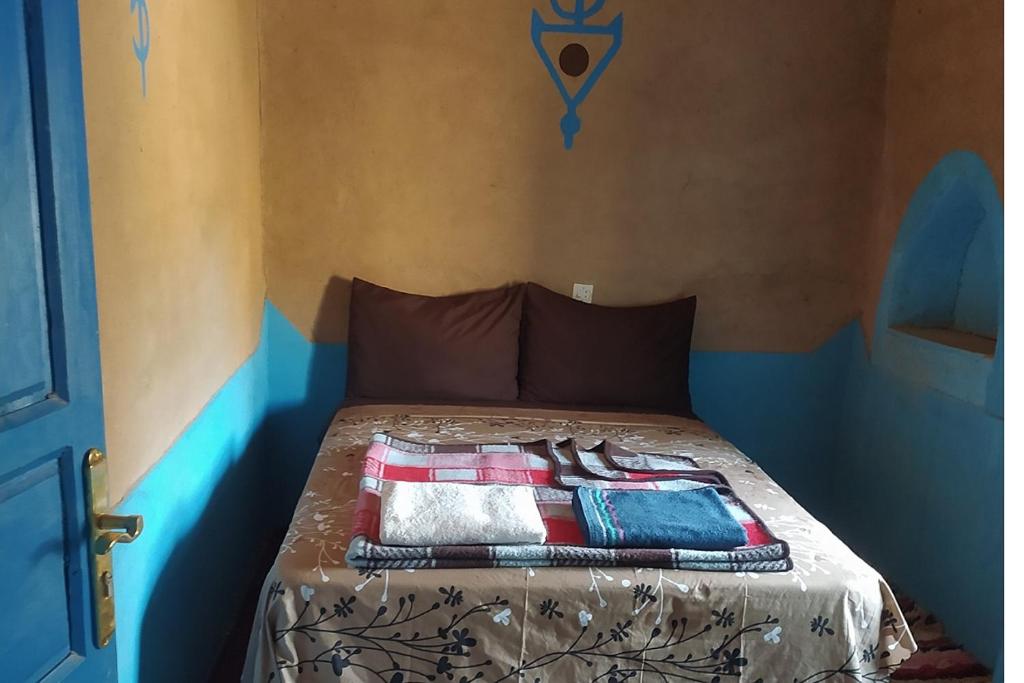 a bed with a blanket on top of it at Desert house in Merzouga
