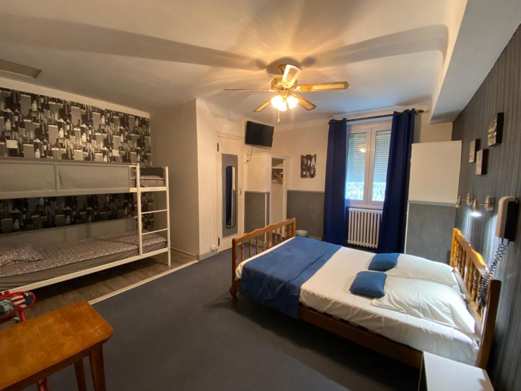 una camera da letto con un letto e un ventilatore a soffitto di Au Royal Hotel a Carcassonne