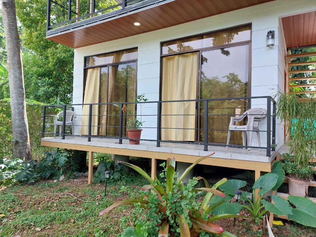 uma casa com uma varanda com duas cadeiras em El Tucan em Hone Creek