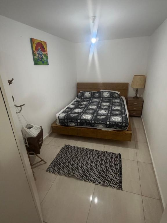 a bedroom with a bed and a light on the wall at יחידת דיור חדשה עם מקלט - היחידה בגליל in Qiryat Shemona