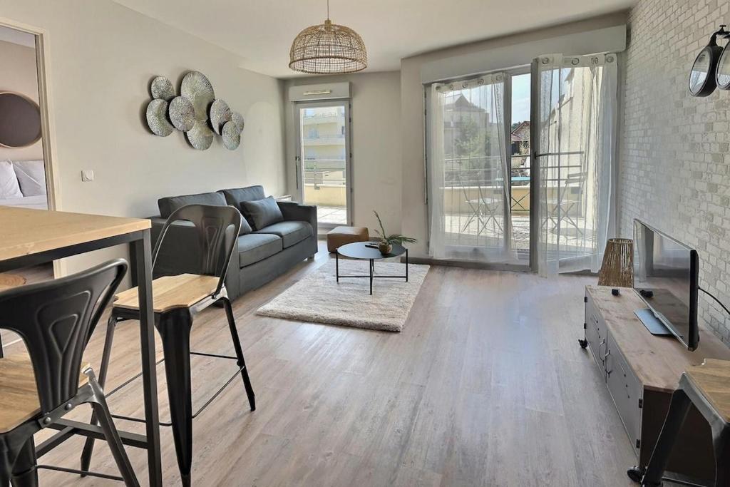 ein Wohnzimmer mit Sofa und Tisch in der Unterkunft Le Manet, Lagny-sur-Marne in Lagny