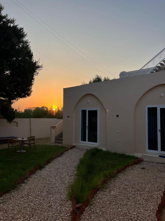 una casa con la puesta de sol en el fondo en Paradise Luxor, en Luxor