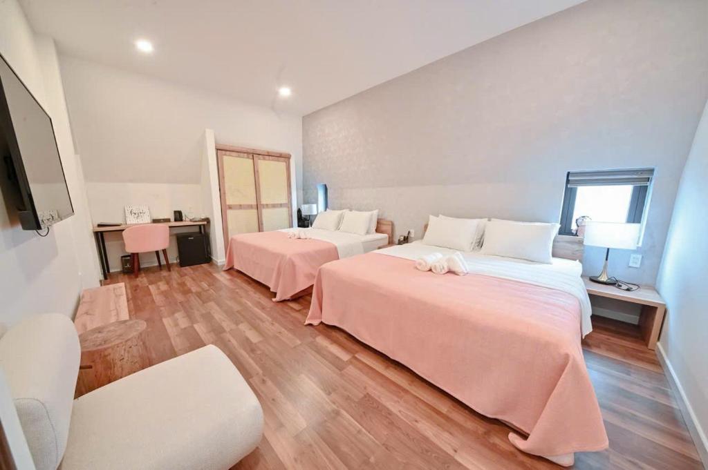 Kon Rung (1)Swan Suite Villa Đà Lạt的有两张床和一张桌子的大房间
