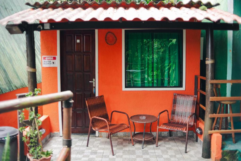 un patio con sillas y una mesa frente a una casa en CASA DA ILHA INN and SPA Anexo2, en Angra dos Reis