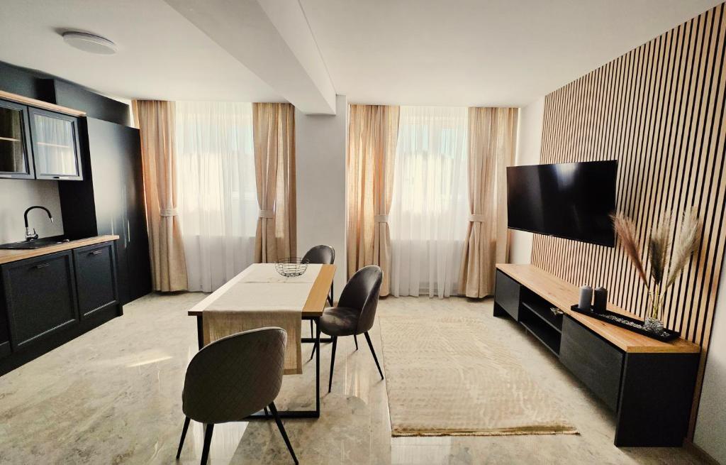 a living room with a table and a flat screen tv at HOTEL APARTS by RALEX in Pucioasa