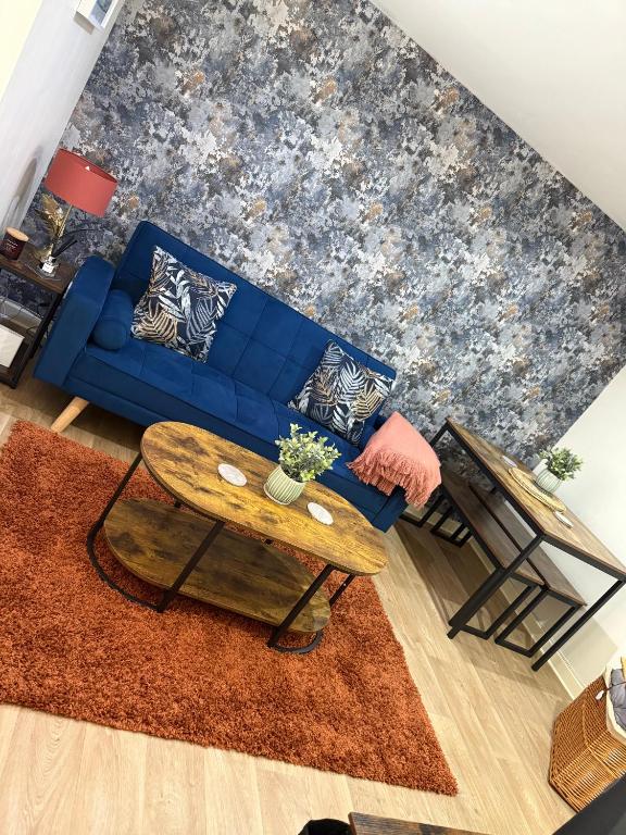 a living room with a blue couch and a table at Erskine Apartment-Small and Cosy 1 Bedroom Apartment in Angus