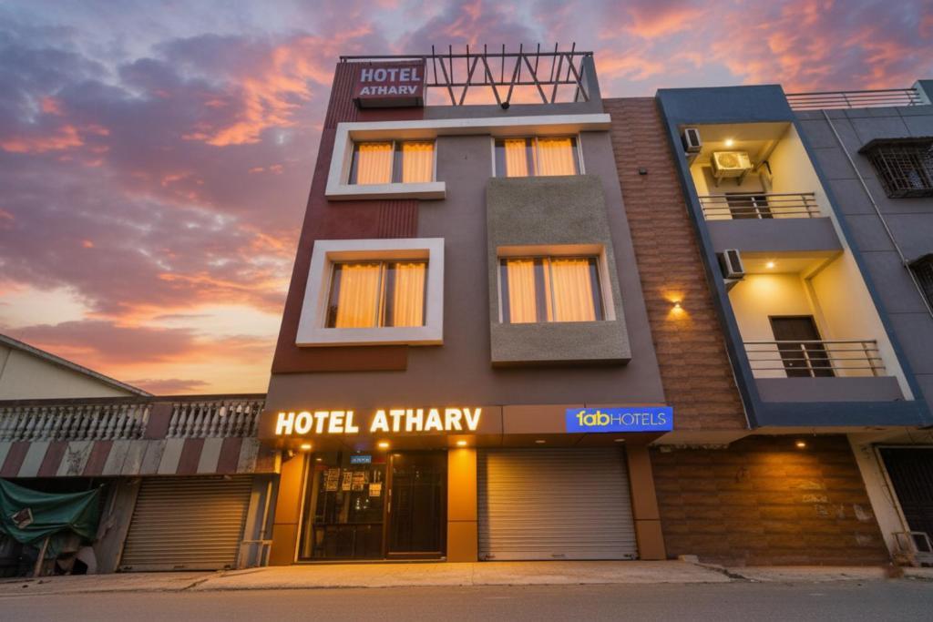 a hotel apartment building with the sunset in the background at FabHotel Atharv - Airport in Indore