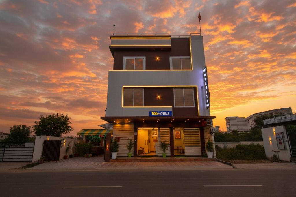 a building with a sunset in the background at FabHotel The Gravity Inn in Indore