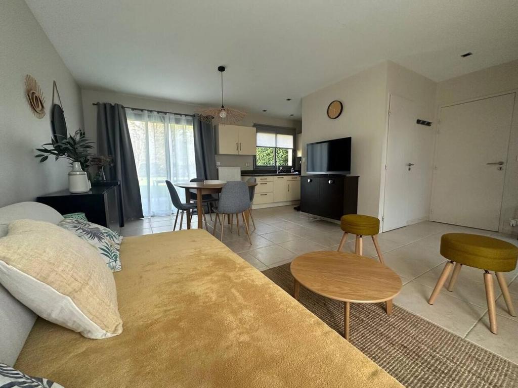 a living room with a couch and a table with chairs at Les Alois 10 min to Disneyland in Couilly-Pont-aux-Dames