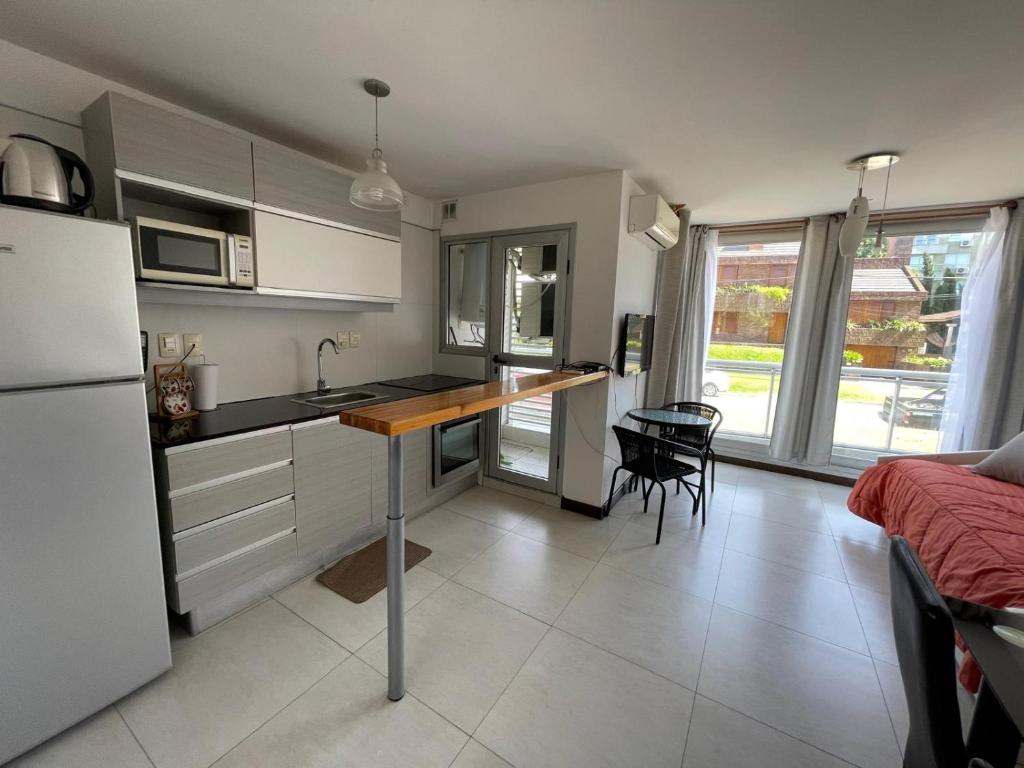 eine Küche mit einem Kühlschrank und einem Tisch darin in der Unterkunft Altos Del Plata 105 y 505 Colonia Uruguay in Colonia del Sacramento
