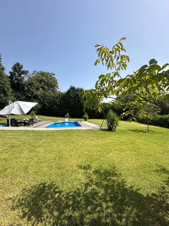 a swimming pool in a yard with a grass field at Quinta da Costa in Monsul
