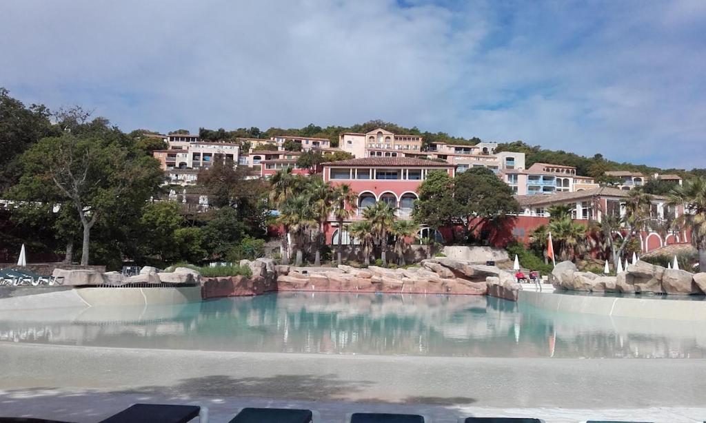 a large pool of water in front of a resort at Appartement Belle vue mer, au calme avec climatisation et wifi 4 personnes in Grimaud