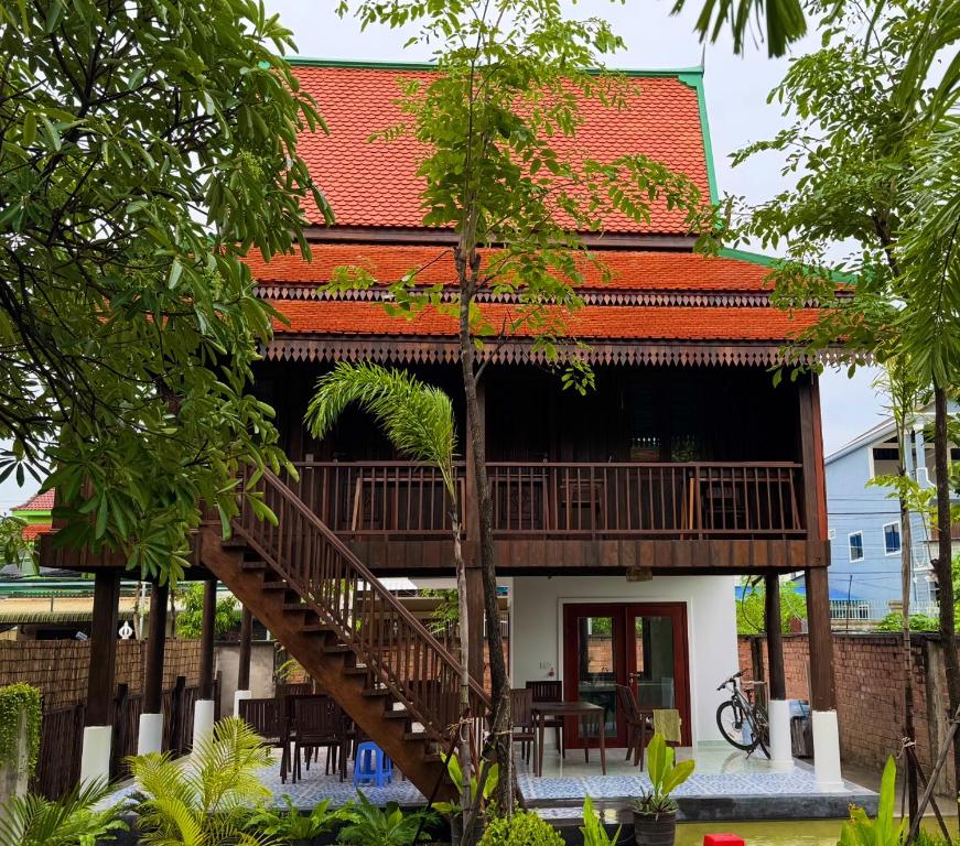 a house with a staircase leading up to it at Sala Khmer Heritage - Siem Reap Traditional Wooden House in Siem Reap