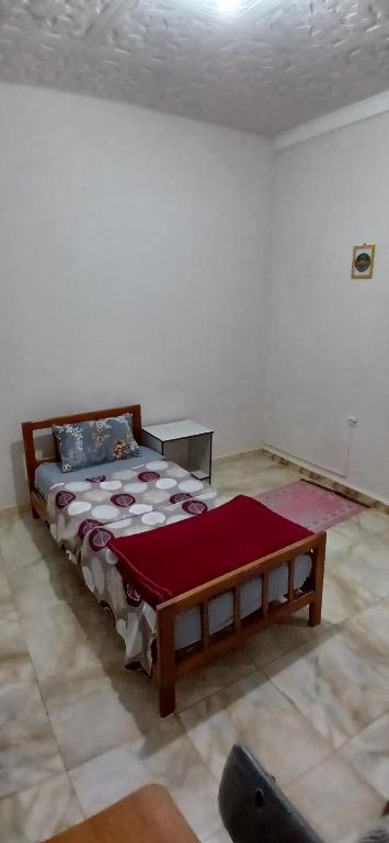 a bedroom with a wooden bed in a room at Hostel 1er novembre khenchela in Khenchela