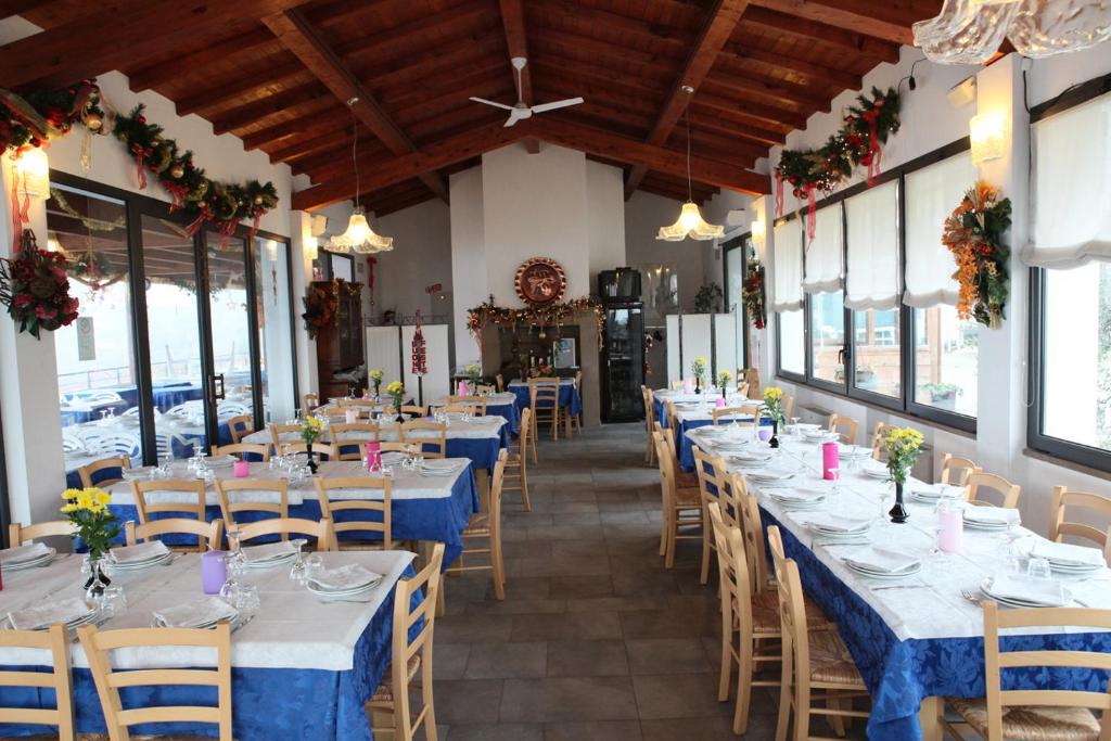 eine Reihe von Tischen in einem Restaurant mit blauen Tischen und Stühlen in der Unterkunft Agriturismo Apollinare in Montiano