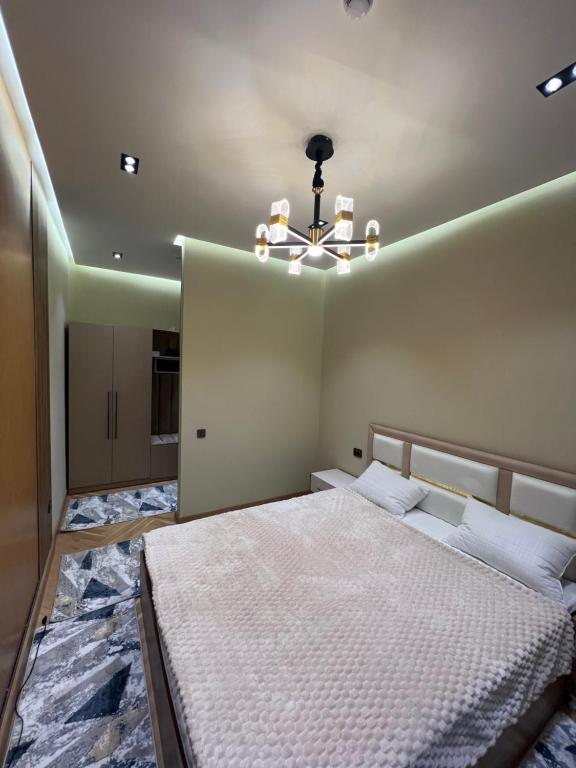a bedroom with a large bed and a chandelier at Apartments in Tashkent Uzbekistan in Toshkent-Passajir Bekati